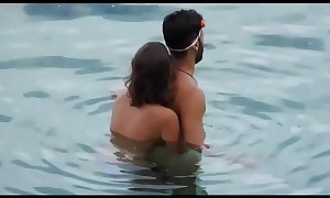 Girl gives her man a reacharound in the ocean at the beach