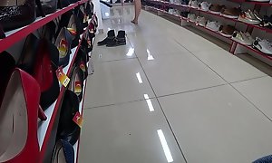 Voyeur and foot fetish in a public place. Beautiful legs in stockings and a juicy ass under a short dress in a shoe store.